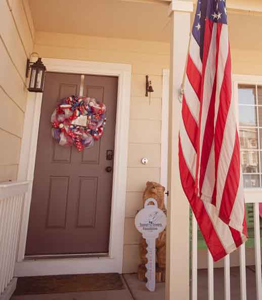 photo of front doorstep with patriotic wreath, american flag